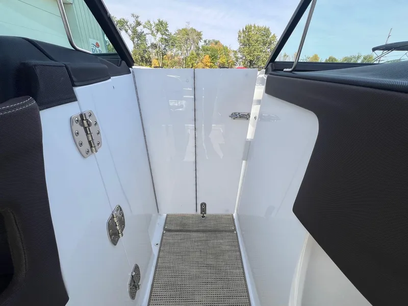 Slide: The Image of Interior view of a 2016 Cobalt R30 boat, featuring sleek white panels and metal hinges. - 16