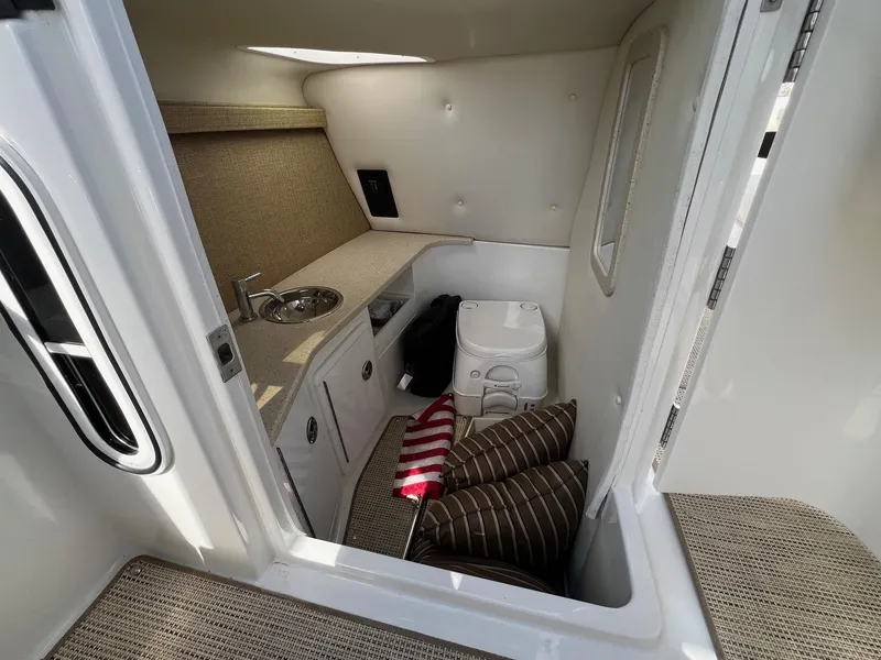 Slide: The Image of 2016 Cobalt R30 boat interior with compact sink, toilet, and striped cushions. - 33