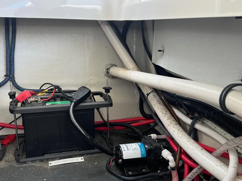 Slide: The Image of 2016 Cobalt R30 boat battery and wiring compartment with visible cables and pump. - 45