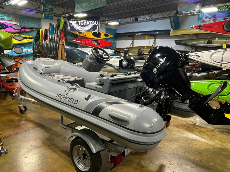 The Image of 2025 Highfield Classic 310 FCT inflatable boat with Tohatsu outboard motor in showroom. - 1