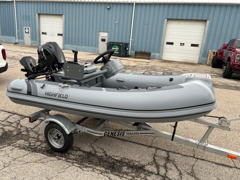 Slide: The Image of 2025 Highfield Classic 310 FCT inflatable boat on Genesis trailer, parked outdoors. - 4
