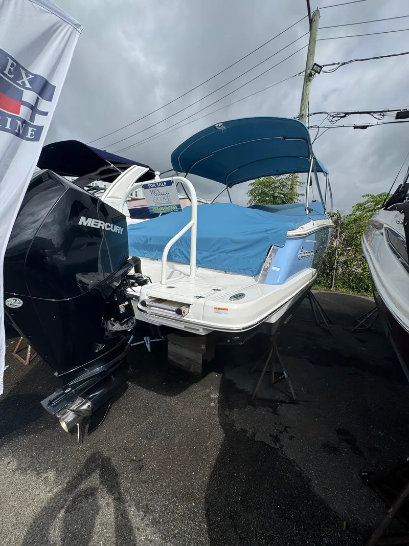 Slide: The Image of 2022 Chaparral 267 SSX OB boat with blue cover and Mercury outboard motor. - 2