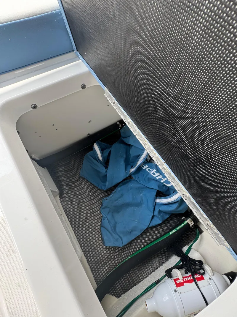 Slide: The Image of Storage compartment in 2022 Chaparral 267 SSX OB boat with blue fabric and equipment. - 20