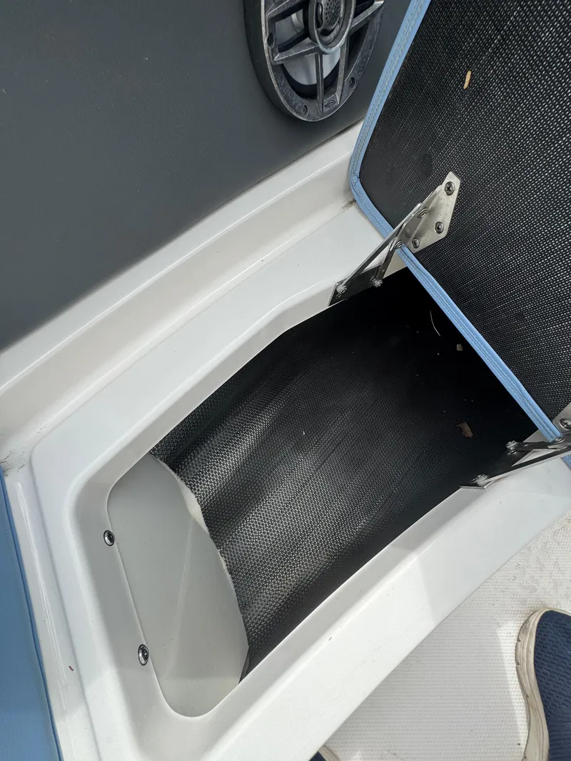 Slide: The Image of Open storage compartment on a 2022 Chaparral 267 SSX OB boat. - 25
