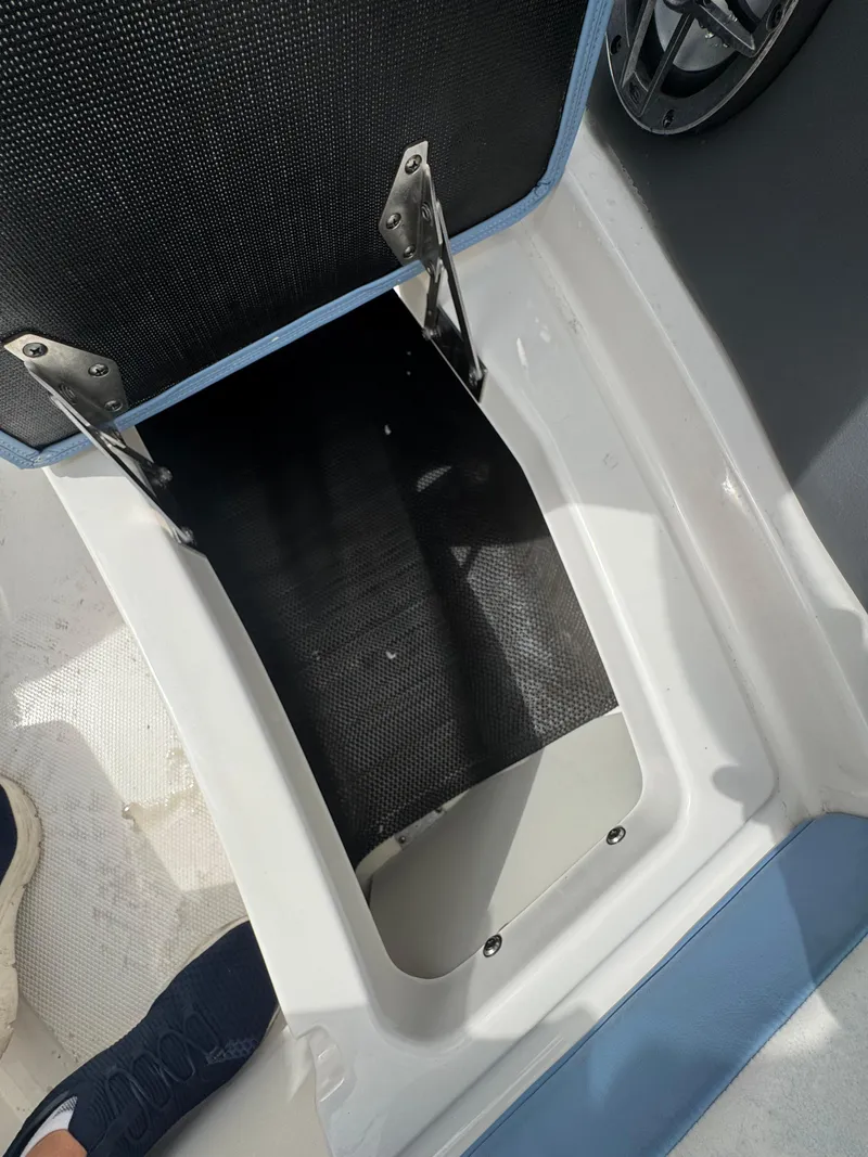 Slide: The Image of Open storage compartment on 2022 Chaparral 267 SSX OB boat, showing interior details. - 27