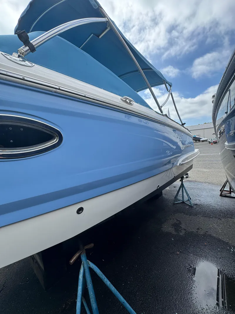 Slide: The Image of 2022 Chaparral 267 SSX OB boat in blue, displayed on stands outdoors. - 7