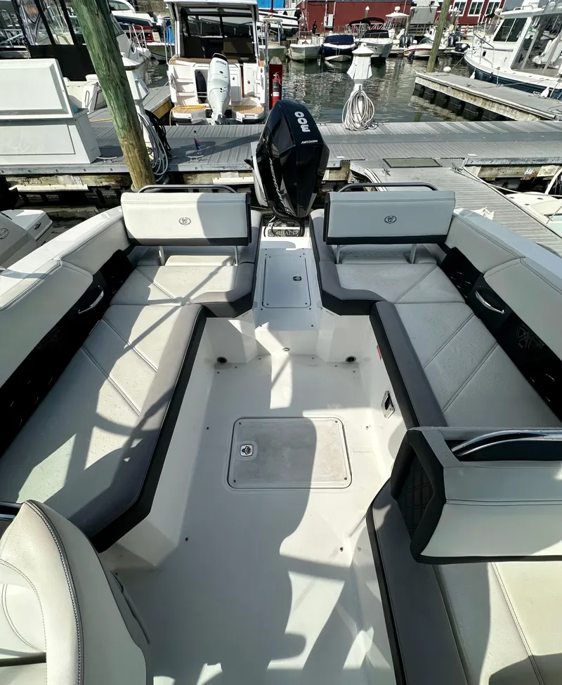 Slide: The Image of 2022 Cobalt R6 Outboard boat interior, featuring spacious seating and modern design at a marina. - 11