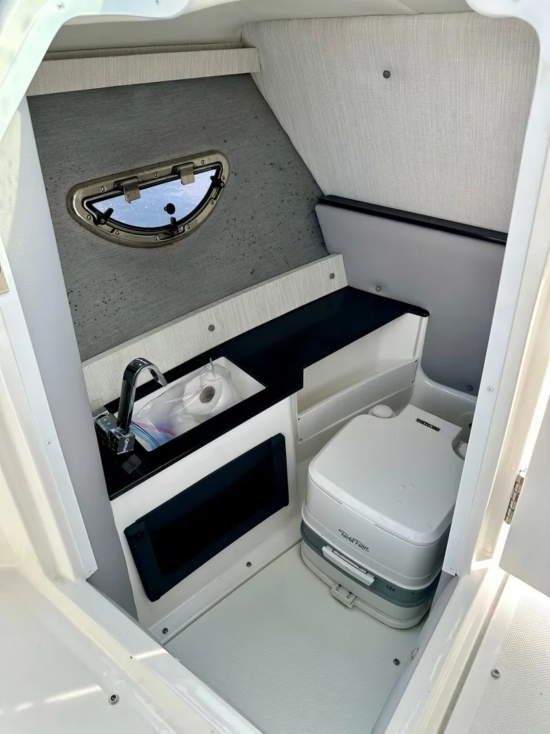 Slide: The Image of 2022 Cobalt R6 Outboard boat interior with sink and portable toilet. - 8