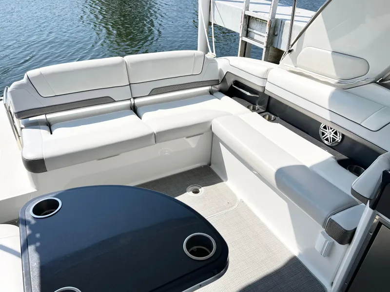 Slide: The Image of 2018 Formula 330 CRB boat interior with white seating and table, docked by water. - 13