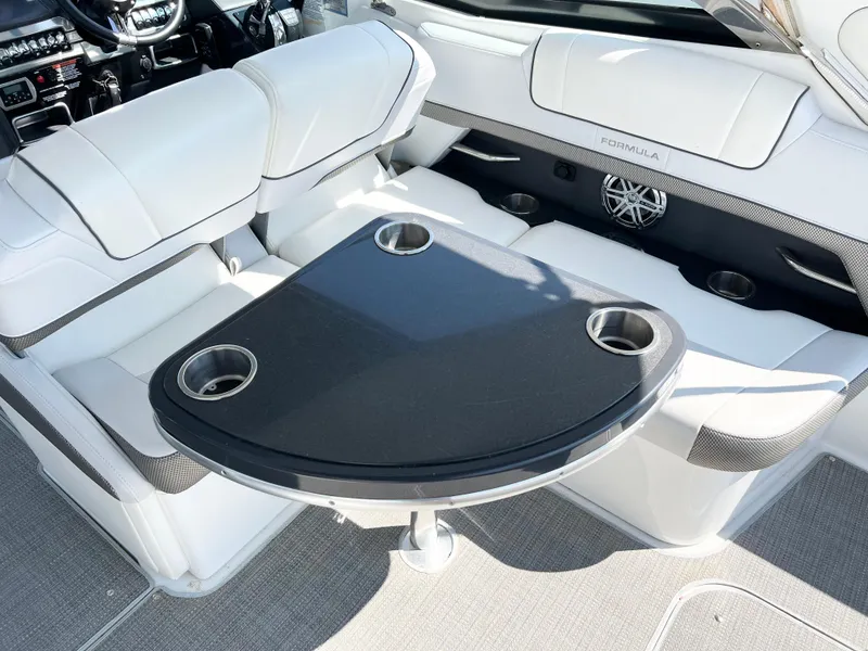 Slide: The Image of 2018 Formula 330 CRB boat interior with seating and table featuring cup holders. - 8