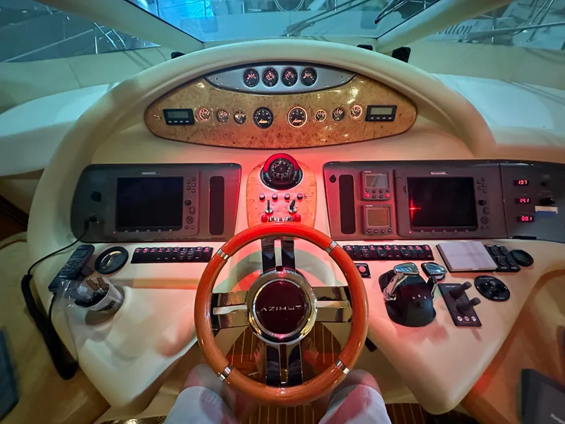 Slide: The Image of Cockpit of 2011 Azimut 62E yacht with advanced navigation controls and wooden steering wheel. - 13