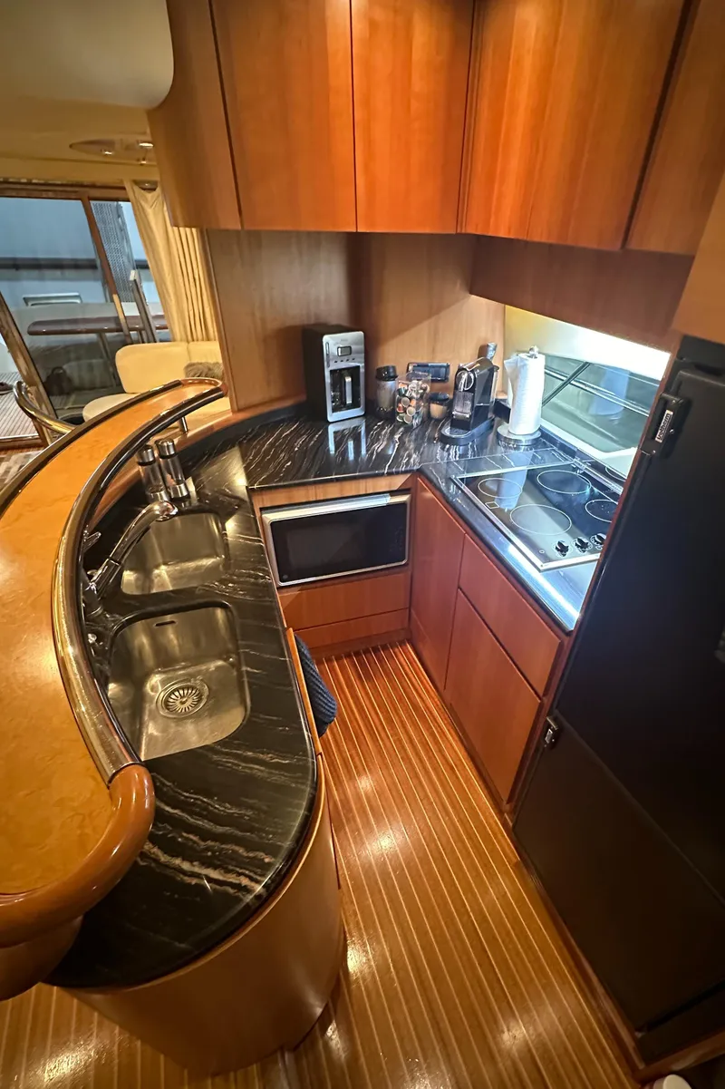 Slide: The Image of Luxurious kitchen in 2011 Azimut 62E yacht with sleek wood cabinetry and modern appliances. - 22