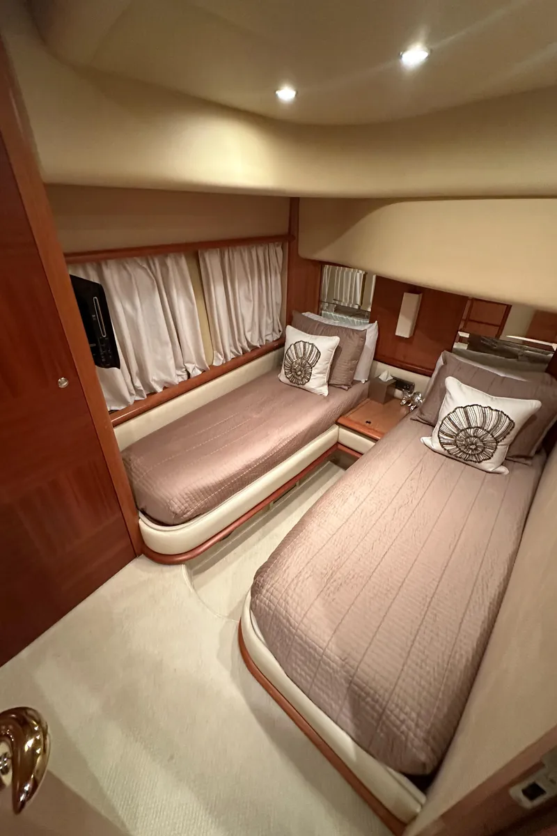 Slide: The Image of 2011 Azimut 62E yacht cabin with twin beds, elegant decor, and soft lighting. - 26