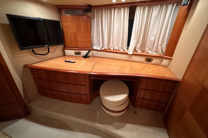 Slide: The Image of 2011 Azimut 62E yacht interior with wooden desk, TV, and curtains. - 39