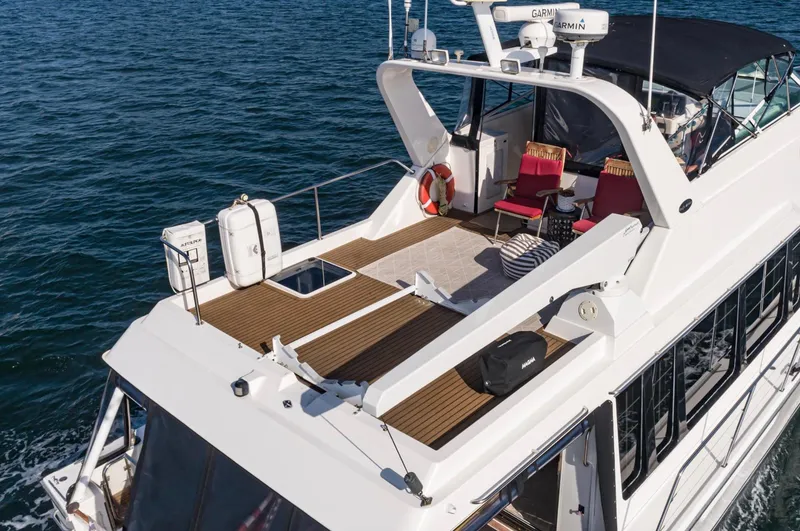 Slide: The Image of 1998 Pacific Mariner 65 Motoryacht on water, featuring spacious deck and seating area. - 14