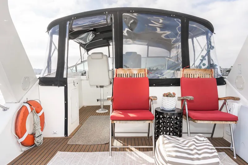 Slide: The Image of 1998 Pacific Mariner 65 Motoryacht deck with red chairs and a table. - 17