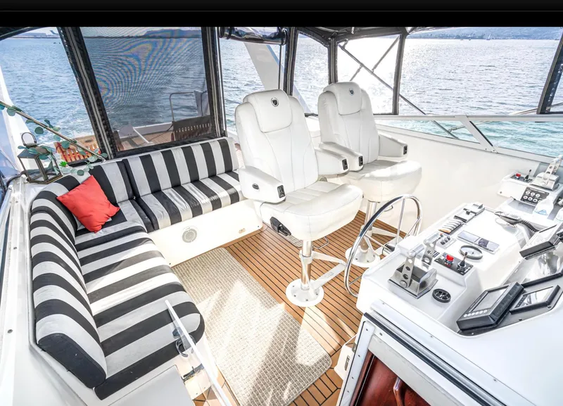 Slide: The Image of Luxurious 1998 Pacific Mariner 65 Motoryacht cockpit with striped seating and modern controls. - 18
