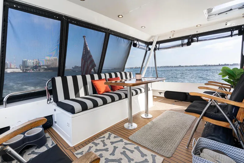 Slide: The Image of 1998 Pacific Mariner 65 Motoryacht interior with striped seating, table, and ocean view. - 22