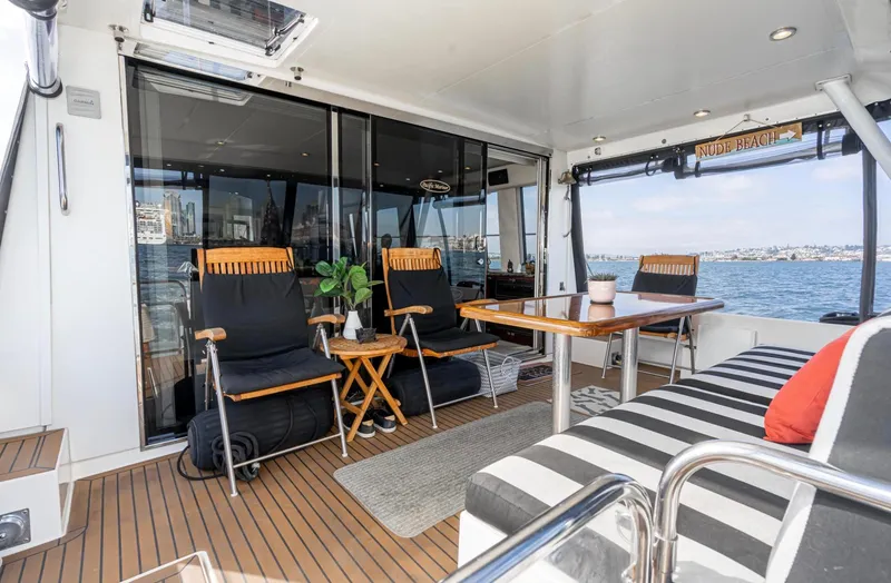 Slide: The Image of 1998 Pacific Mariner 65 Motoryacht deck with seating, table, and ocean view. - 23