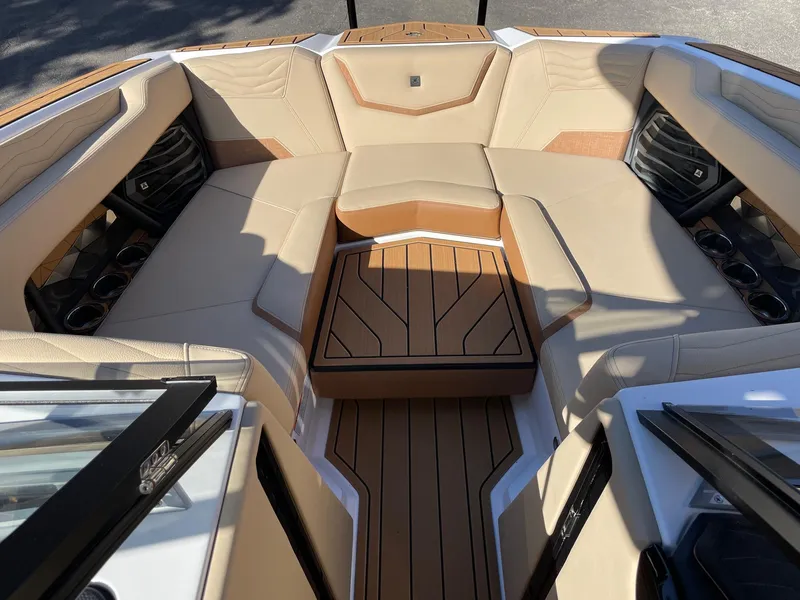 Slide: The Image of 2025 Nautique Super Air Nautique G23 boat interior with beige seating and wood accents. - 11