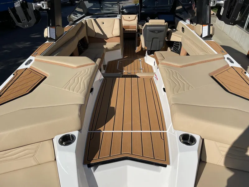 Slide: The Image of 2025 Nautique Super Air Nautique G23 interior with tan upholstery and teak flooring. - 4