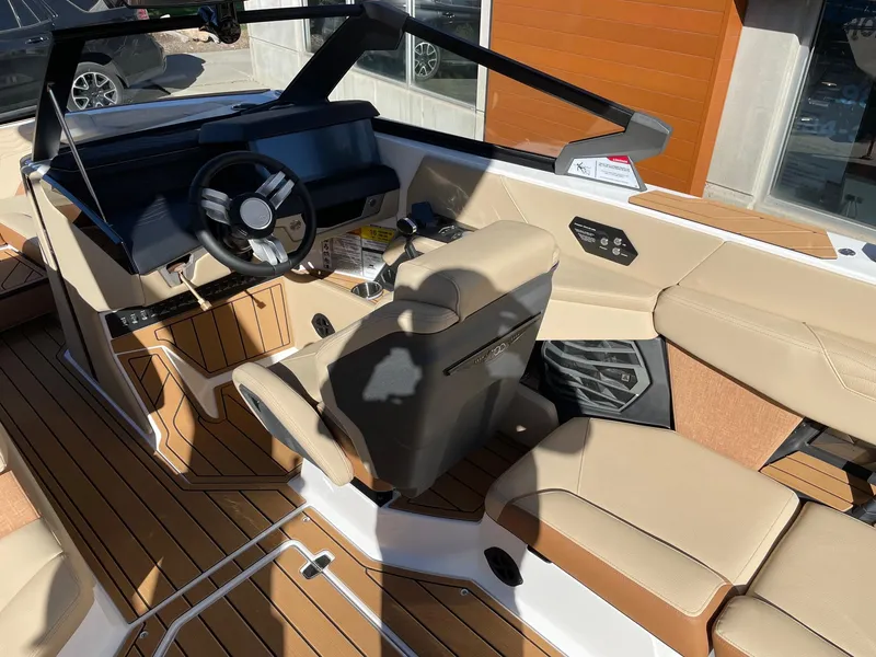 Slide: The Image of 2025 Nautique Super Air Nautique G23 interior with beige seating and modern dashboard. - 6