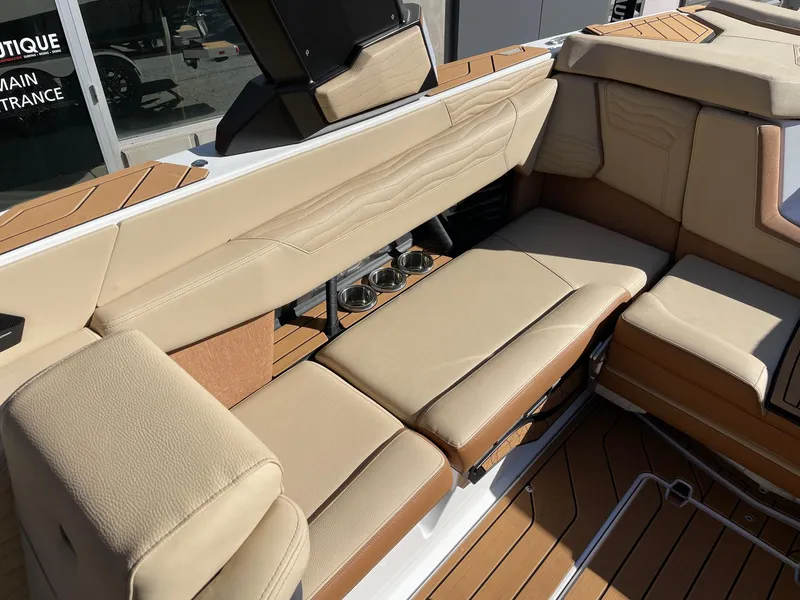 Slide: The Image of 2025 Nautique Super Air Nautique G23 interior with beige leather seating and teak flooring. - 7