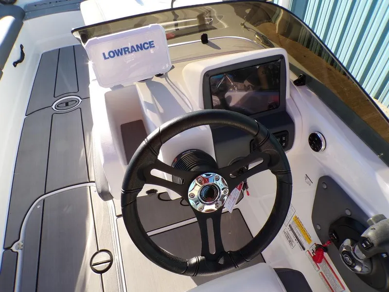 Slide: The Image of 2025 Tahoe T21 boat cockpit with steering wheel and Lowrance navigation system. - 16