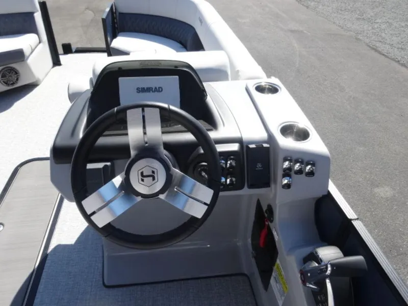 Slide: The Image of 2025 Harris SUNLINER SP 250 boat dashboard with steering wheel and controls. - 9