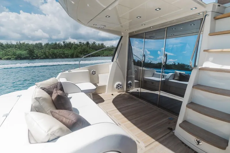 Slide: The Image of Luxurious 2015 Beneteau Monte Carlo 5 yacht deck with seating, stairs, and scenic water view. - 15