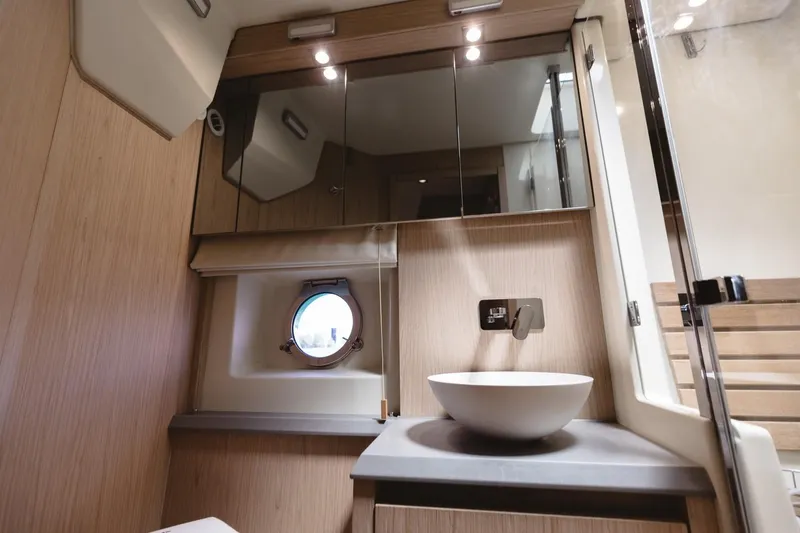 Slide: The Image of Luxurious bathroom in 2015 Beneteau Monte Carlo 5 yacht with modern fixtures and porthole window. - 21