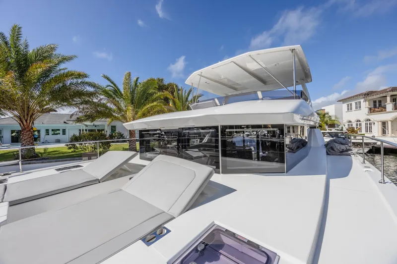 Slide: The Image of 2024 Leopard 53 Powercat yacht with sun deck, docked near palm trees and waterfront homes. - 16