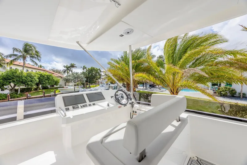 Slide: The Image of 2024 Leopard 53 Powercat helm with modern controls, surrounded by tropical scenery. - 2