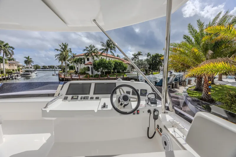 Slide: The Image of 2024 Leopard 53 Powercat helm with waterfront view, palm trees, and luxury homes. - 3