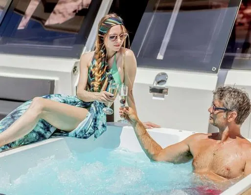 Slide: The Image of Couple enjoying a toast in the jacuzzi on a 2025 Fountaine Pajot Power 67 yacht. - 12