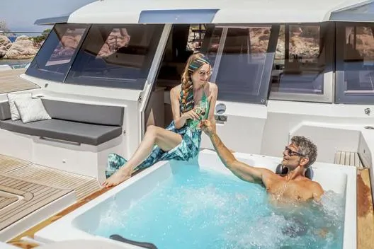 Slide: The Image of Couple enjoying jacuzzi on 2025 Fountaine Pajot Power 67 yacht deck. - 13