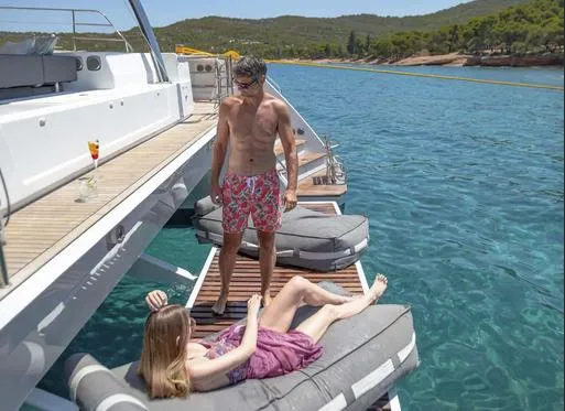 Slide: The Image of Couple relaxing on Fountaine Pajot Power 67 yacht, 2025, in scenic coastal waters. - 14