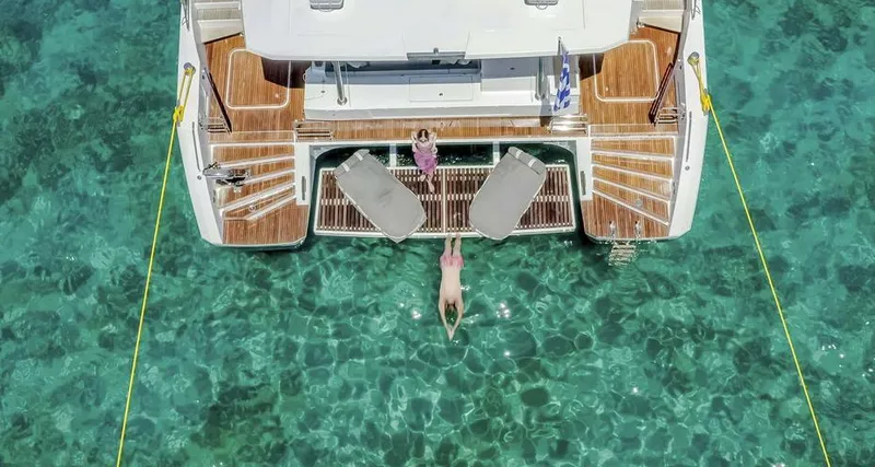 Slide: The Image of Aerial view of 2025 Fountaine Pajot Power 67 yacht with people relaxing on deck. - 15