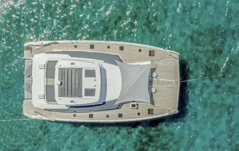 Slide: The Image of Aerial view of 2025 Fountaine Pajot Power 67 yacht on clear turquoise water. - 16