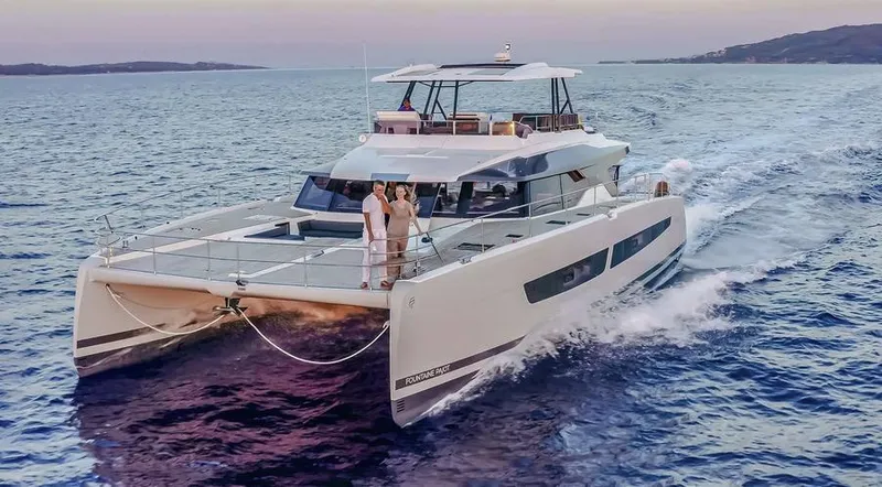 Slide: The Image of 2025 Fountaine Pajot Power 67 yacht cruising on open water at sunset. - 3