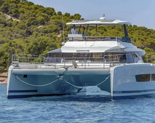 Slide: The Image of 2025 Fountaine Pajot Power 67 catamaran cruising in clear blue waters near a lush coastline. - 7