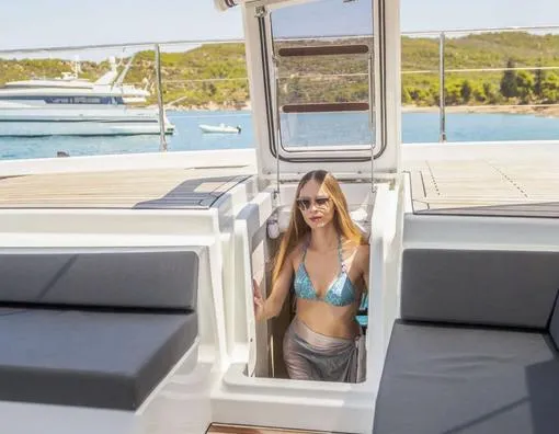 Slide: The Image of Woman on Fountaine Pajot Power 67 yacht, 2025 model, enjoying sunny deck view. - 8