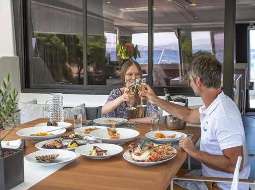 Slide: The Image of Couple enjoying a seafood meal on a 2025 Fountaine Pajot Power 67 yacht. - 9