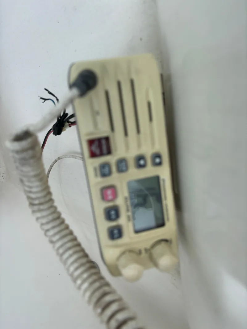 Slide: The Image of 2008 Angler 204WA boat radio with coiled cord and control panel. - 31