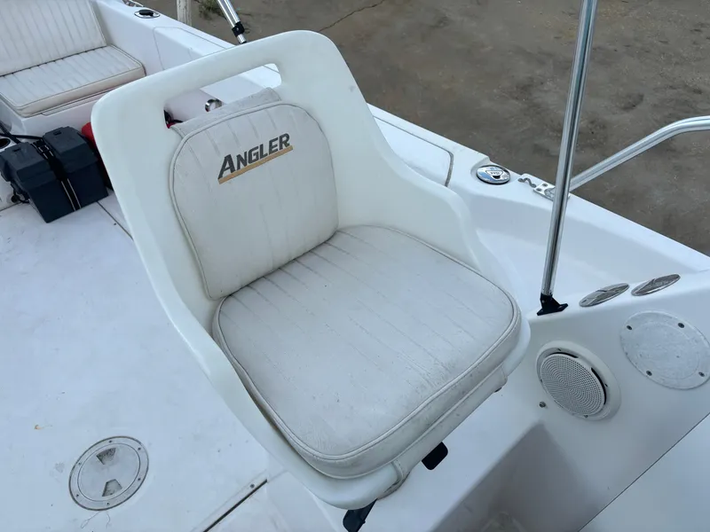 Slide: The Image of 2008 Angler 204WA boat seat with logo, white upholstery, and surrounding deck area. - 48
