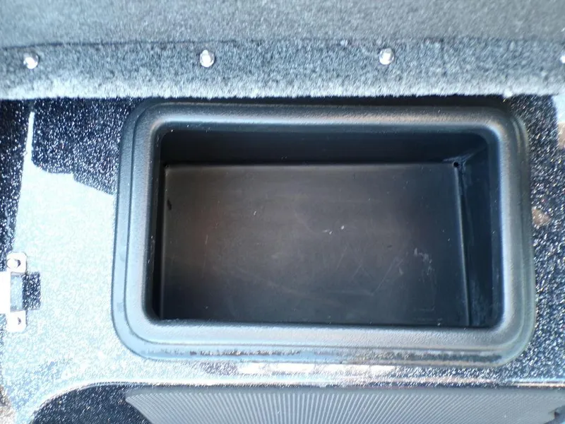 Slide: The Image of 2025 Skeeter FXR20L storage compartment, black interior, carpeted edges. - 21