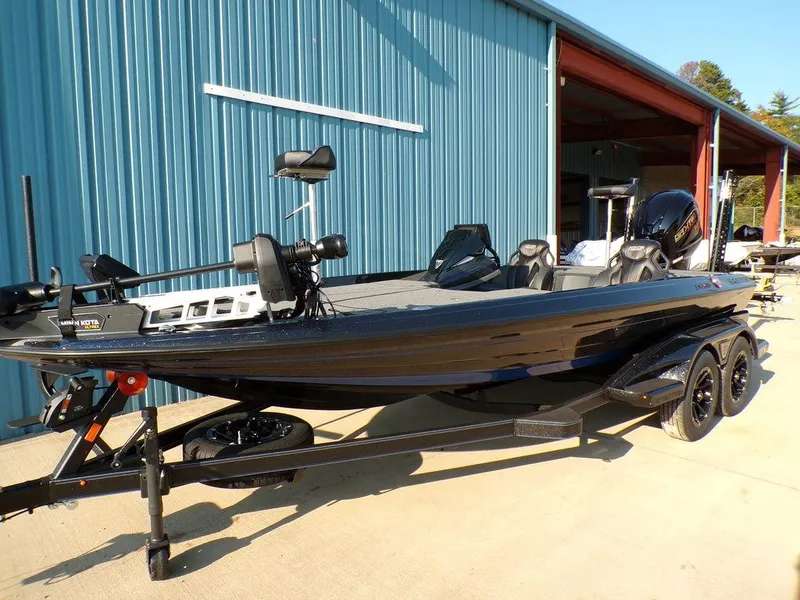 Slide: The Image of 2025 Skeeter FXR20L bass boat parked outside a blue building. - 3