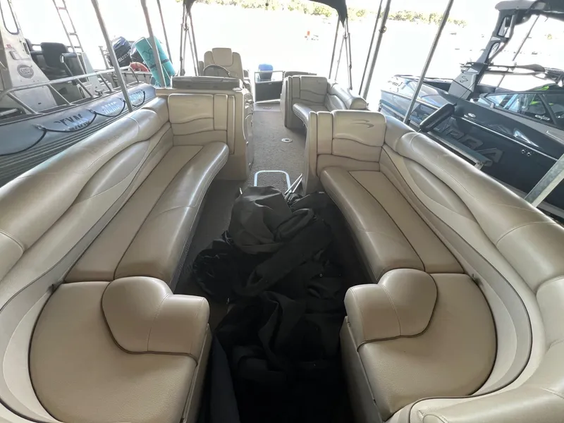 Slide: The Image of 2012 Bennington 25 RCW boat interior with beige seating and spacious layout. - 17