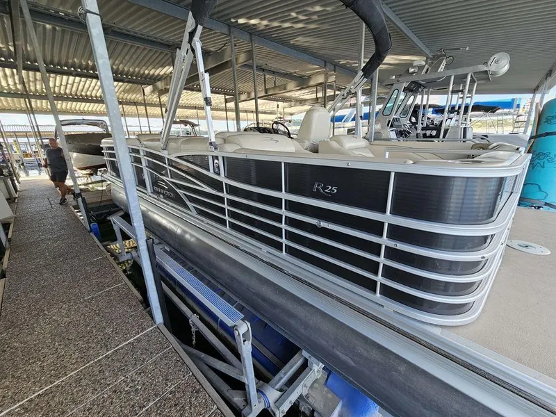 Slide: The Image of 2012 Bennington 25 RCW pontoon boat docked in a covered marina. - 3