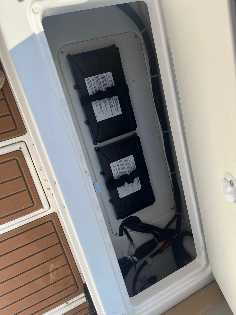 Slide: The Image of Battery compartment of 2025 Bayliner Trophy T22CC boat, showing two batteries and wiring. - 10